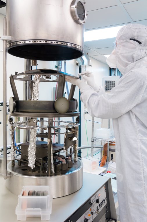 A researcher reaching into an opened evaporator chamber